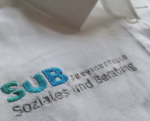 Poloshirt Nahaufnahme mit Wortbildmarke Servicestelle Soziales und Beratung